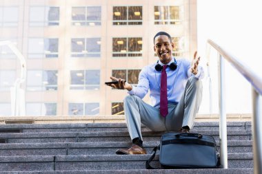 Handsome male african american business man CEO in a stylish corporate elegant suit in a business center outdoors - Black male commuter going to work, city and financial district in the background