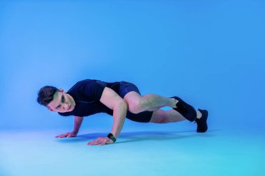 Stüdyoda kaslı vücut eğitimi almış atletik bir adam aktif bir adam spor yapıyor, renkli ışıklandırma ve arka plan, fitness, spor ve sağlık yaşam tarzı konseptleri