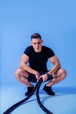 Stüdyoda kaslı vücut eğitimi almış atletik bir adam aktif bir adam spor yapıyor, renkli ışıklandırma ve arka plan, fitness, spor ve sağlık yaşam tarzı konseptleri