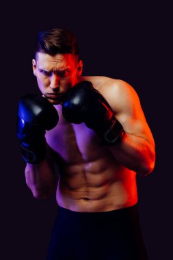 Stüdyoda kaslı vücut eğitimi almış atletik bir adam aktif bir adam spor yapıyor, renkli ışıklandırma ve arka plan, fitness, spor ve sağlık yaşam tarzı konseptleri