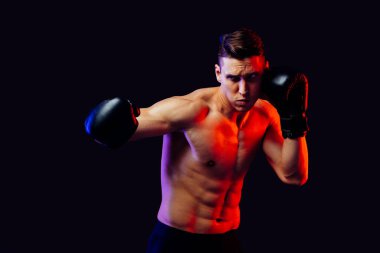 Stüdyoda kaslı vücut eğitimi almış atletik bir adam aktif bir adam spor yapıyor, renkli ışıklandırma ve arka plan, fitness, spor ve sağlık yaşam tarzı konseptleri