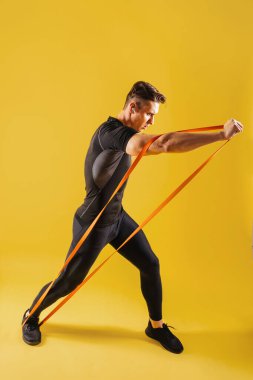 Stüdyoda kaslı vücut eğitimi almış atletik bir adam aktif bir adam spor yapıyor, renkli ışıklandırma ve arka plan, fitness, spor ve sağlık yaşam tarzı konseptleri