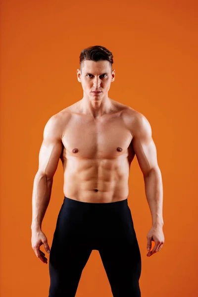スタジオでの筋肉のトレーニングに適したアスレチックマン ワークアウト カラフルな照明と背景 フィットネス スポーツ 健康ライフスタイルに関する概念を行うアクティブな男 — ストック写真