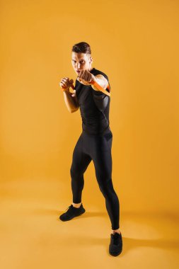 Stüdyoda kaslı vücut eğitimi almış atletik bir adam aktif bir adam spor yapıyor, renkli ışıklandırma ve arka plan, fitness, spor ve sağlık yaşam tarzı konseptleri