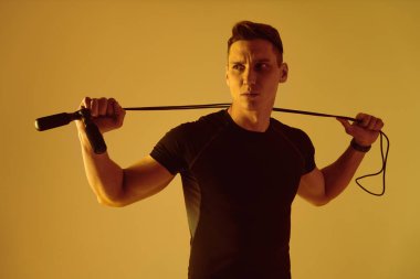 Stüdyoda kaslı vücut eğitimi almış atletik bir adam aktif bir adam spor yapıyor, renkli ışıklandırma ve arka plan, fitness, spor ve sağlık yaşam tarzı konseptleri