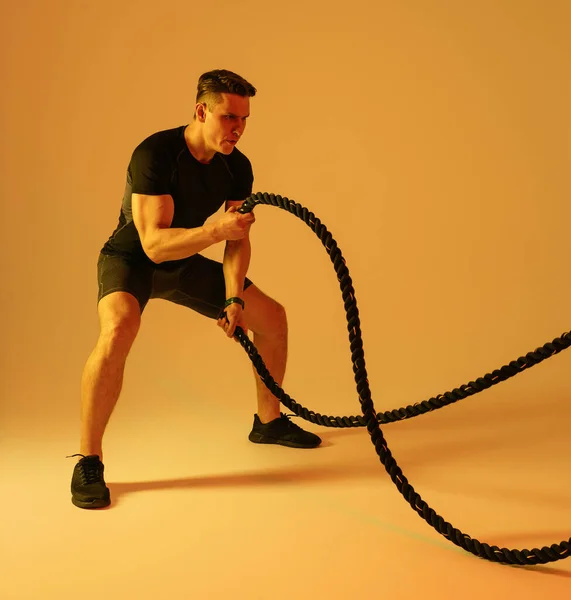 stock image Athletic man with fit muscular body training in studio - Active man doing a workout, colorful lighting and background, concepts about fitness, sport and health lifestyle