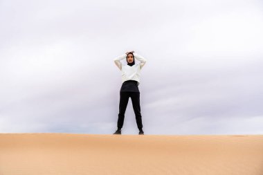Ortadoğulu güzel bir Arap kadın çölde tesettür eğitimi alıyor sportif atletik müslüman kadın, burkini spor kıyafetleri giyiyor spor yapıyor.