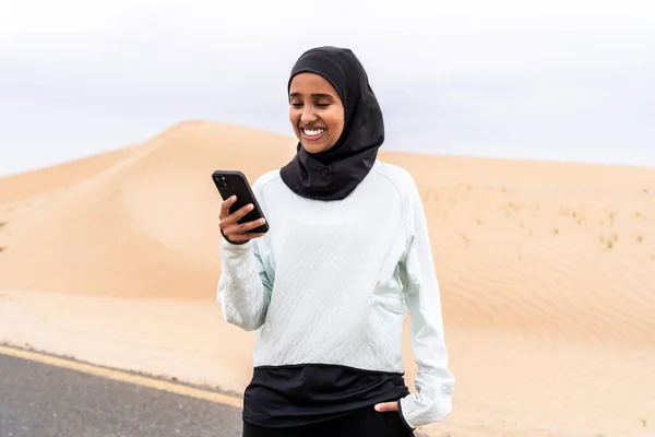 stock image Beautiful middle-eastern arab woman wearing hijab training outdoors in a desert area - Sportive athletic muslim adult female wearing burkini sportswear doing fitness workout