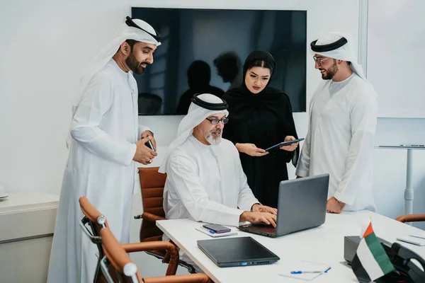 ドバイのオフィスで伝統的なエミレーツの服を着ている中東の企業ビジネスのグループ Uaeで働くビジネスチームとブレインストーミング — ストック写真