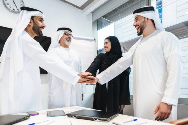 Dubai 'deki ofiste geleneksel emirati kıyafetleri giyen bir grup orta doğulu iş adamı BAE' de çalışıyor ve beyin fırtınası yapıyor.