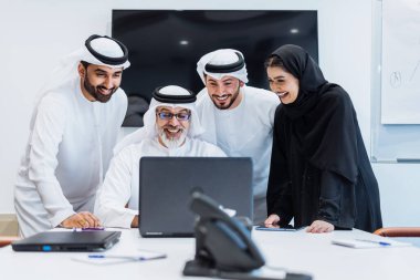 Dubai 'deki ofiste geleneksel emirati kıyafetleri giyen bir grup orta doğulu iş adamı BAE' de çalışıyor ve beyin fırtınası yapıyor.