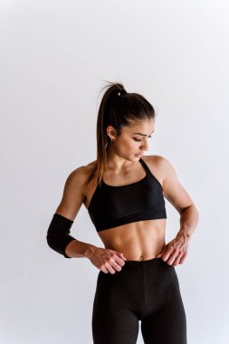 Spor aletlerini kullanarak spor salonunda antrenman yapan genç bir bayan sporcu. Formda kadın vücut çalışıyor. Zindelik, sağlık ve spor hazırlığı kavramları.