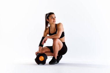 Spor aletlerini kullanarak spor salonunda antrenman yapan genç bir bayan sporcu. Formda kadın vücut çalışıyor. Zindelik, sağlık ve spor hazırlığı kavramları.