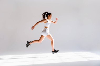 Spor aletlerini kullanarak spor salonunda antrenman yapan genç bir bayan sporcu. Formda kadın vücut çalışıyor. Zindelik, sağlık ve spor hazırlığı kavramları.