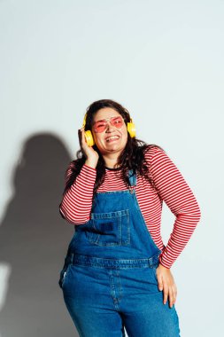 Artı stüdyoda poz veren ve eğlenen boy kadın modeller. Beyaz arka planda çekimler ve doğrudan sert ışık