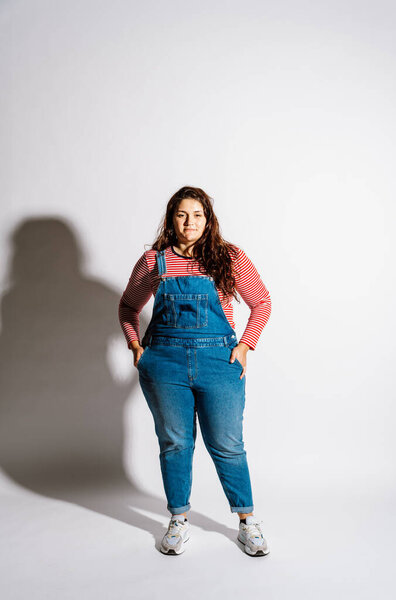 Plus size woman model posing in studio and having fun. Shots taken on white background and direct hard light