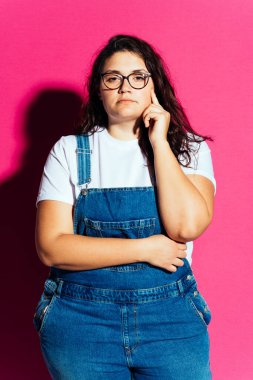 Ayrıca stüdyoda poz veren ve renkli arka planlarda eğlenen cüsseli bir kadın. Direkt stüdyo ışık çekimleri