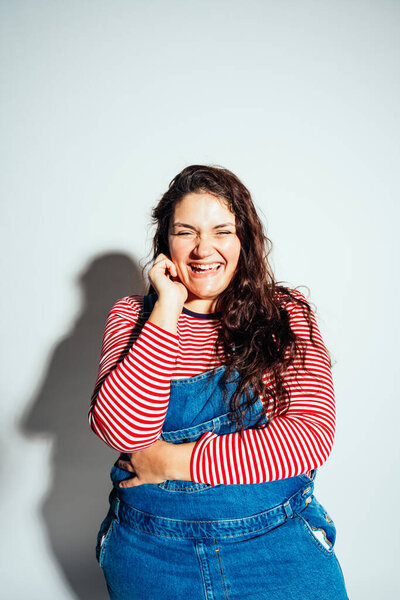 Plus size woman model posing in studio and having fun. Shots taken on white background and direct hard light