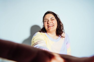 Artı stüdyoda poz veren ve eğlenen boy kadın modeller. Beyaz arka planda çekimler ve doğrudan sert ışık