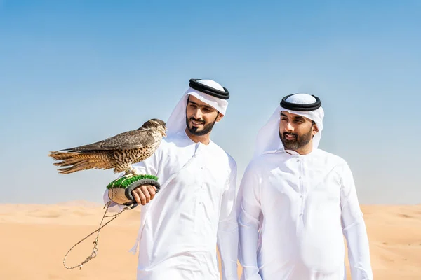 Двое Мужчин Ближнего Востока Одетых Традиционную Эмиратскую Кандуру Сближаются Пустыне — стоковое фото