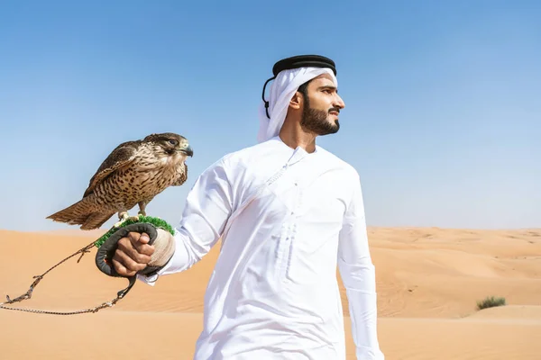 在沙漠中穿着传统的亚拉提 阿拉布 坎杜拉的中东男人 带着猎鹰鸟 迪拜沙丘上的阿拉伯穆斯林成年人 — 图库照片
