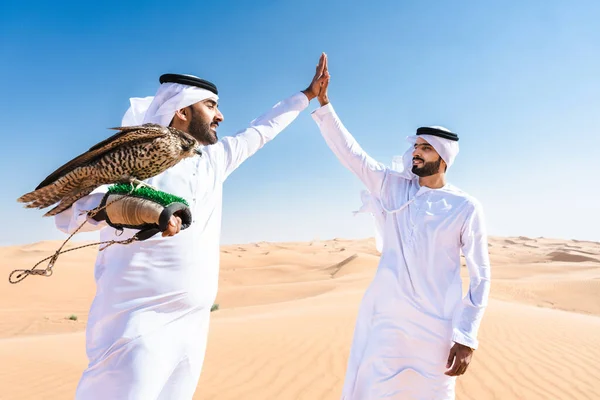 Двое Мужчин Ближнего Востока Одетых Традиционную Эмиратскую Кандуру Сближаются Пустыне — стоковое фото