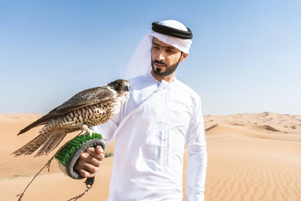 Bliskowschodni Mężczyzna Noszący Tradycyjną Arabską Kandurę Emiratów Pustyni Trzymający Sokolnika — Zdjęcie stockowe