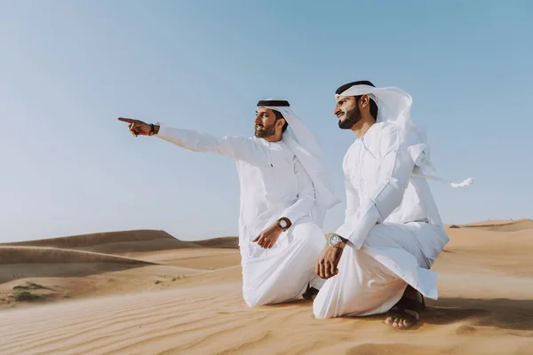 砂漠で伝統的なエミレーツ アラブ カンドゥラの絆を身に着けている中東の2人の男性 ドバイの砂丘で会うアラビア人のイスラム教徒の友人 — ストック写真
