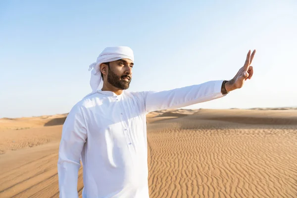 砂漠で伝統的なエミラティ アラブ カンドゥラを身に着けているハンサムで成功した中東人 ドバイの砂丘でのアラビア人ムスリム大人の人 — ストック写真