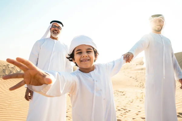 三代家庭穿着白色的坎杜拉服装在迪拜沙漠中进行了一次旅行 儿子和孙子在大自然中呆在一起 — 图库照片