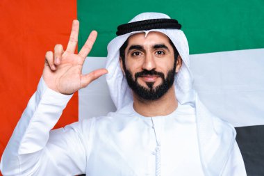 Stüdyoda geleneksel kandorası olan yakışıklı bir Arap. Dubai, Birleşik Arap Emirlikleri 'nde emirli kıyafetler giyen Arap Müslüman erkek portresi.