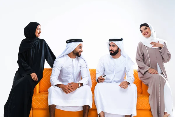 美しいアラブ中東の幸せな友人の友人のグループは 伝統的なアバヤを着て 自宅で結合します アラビアのイスラム教徒の成人はソファに座ってドバイで楽しんでいます アラブ首長国連邦 — ストック写真