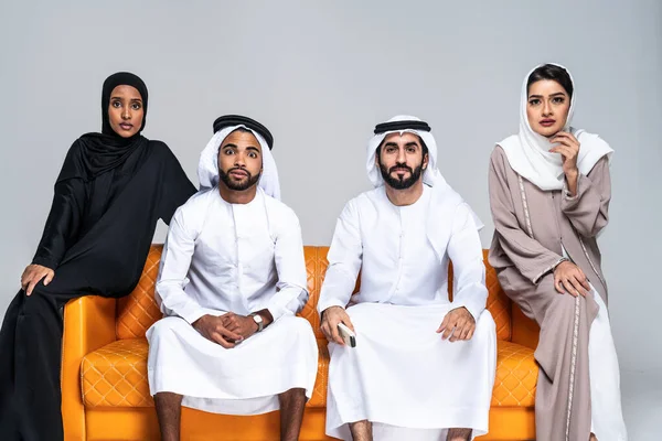 美しいアラブ中東の幸せな友人の友人のグループは 伝統的なアバヤを着て 自宅で結合します アラビアのイスラム教徒の成人はソファに座ってドバイで楽しんでいます アラブ首長国連邦 — ストック写真