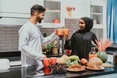 Geleneksel Arap kıyafetleri içinde mutlu bir orta doğu çifti - evli Arap karı-koca evde birbirine bağlanıyor, ilişki kavramları, ev hayatı ve emirati yaşam tarzı