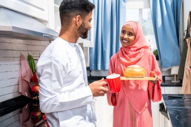 Geleneksel Arap kıyafetleri içinde mutlu bir orta doğu çifti - evli Arap karı-koca evde birbirine bağlanıyor, ilişki kavramları, ev hayatı ve emirati yaşam tarzı