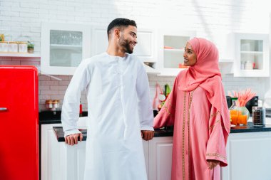 Geleneksel Arap kıyafetleri içinde mutlu bir orta doğu çifti - evli Arap karı-koca evde birbirine bağlanıyor, ilişki kavramları, ev hayatı ve emirati yaşam tarzı