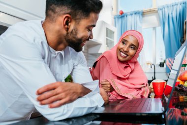 Geleneksel Arap kıyafetleri içinde mutlu bir orta doğu çifti - evli Arap karı-koca evde birbirine bağlanıyor, ilişki kavramları, ev hayatı ve emirati yaşam tarzı