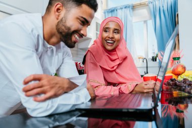 Geleneksel Arap kıyafetleri içinde mutlu bir orta doğu çifti - evli Arap karı-koca evde birbirine bağlanıyor, ilişki kavramları, ev hayatı ve emirati yaşam tarzı