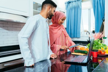 Geleneksel Arap kıyafetleri içinde mutlu bir orta doğu çifti - evli Arap karı-koca evde birbirine bağlanıyor, ilişki kavramları, ev hayatı ve emirati yaşam tarzı