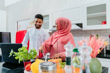 Geleneksel Arap kıyafetleri içinde mutlu bir orta doğu çifti - evli Arap karı-koca evde birbirine bağlanıyor, ilişki kavramları, ev hayatı ve emirati yaşam tarzı