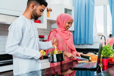 Geleneksel Arap kıyafetleri içinde mutlu bir orta doğu çifti - evli Arap karı-koca evde birbirine bağlanıyor, ilişki kavramları, ev hayatı ve emirati yaşam tarzı