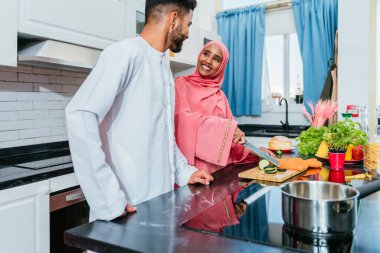 Geleneksel Arap kıyafetleri içinde mutlu bir orta doğu çifti - evli Arap karı-koca evde birbirine bağlanıyor, ilişki kavramları, ev hayatı ve emirati yaşam tarzı