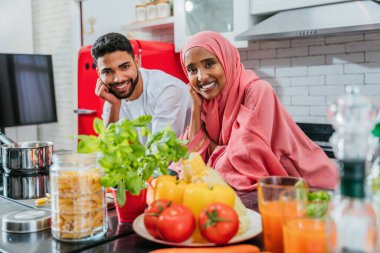 Geleneksel Arap kıyafetleri içinde mutlu bir orta doğu çifti - evli Arap karı-koca evde birbirine bağlanıyor, ilişki kavramları, ev hayatı ve emirati yaşam tarzı