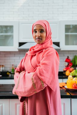 Evde abaya giyen mutlu bir ortadoğulu kadın dairede güzel Müslüman kadın portresi, ev hayatı ve İslami yaşam tarzıyla ilgili kavramlar