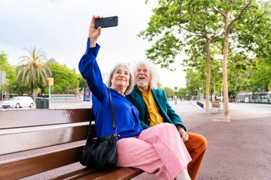 Açık havada flört eden yaşlı bir çift evli yaşlı adam ve aşık bir kadın birlikte vakit geçiriyorlar büyük anne ve büyük baba şehirde gezinirken eğleniyorlar.