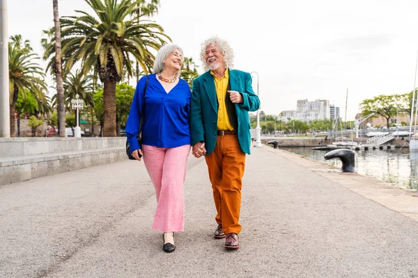 Senior couple of old people dating outdoors - Married elderly man and woman in love spending time together - Grandparents having fun strolling in the city