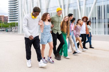 Açık havada kaynaşan neşeli çoklu etnik kökenli genç arkadaş grubu - çok ırklı öğrenciler şehirde buluşuyor, gençlik kavramları, insan yaşam tarzı, çeşitlilik, gençlik ve şehir hayatı