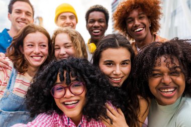 Açık havada kaynaşan neşeli çoklu etnik kökenli genç arkadaş grubu - çok ırklı öğrenciler şehirde buluşuyor, gençlik kavramları, insan yaşam tarzı, çeşitlilik, gençlik ve şehir hayatı