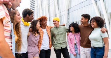 Açık havada kaynaşan neşeli çoklu etnik kökenli genç arkadaş grubu - çok ırklı öğrenciler şehirde buluşuyor, gençlik kavramları, insan yaşam tarzı, çeşitlilik, gençlik ve şehir hayatı