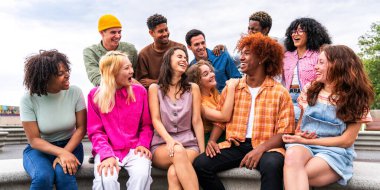 Açık havada kaynaşan neşeli çoklu etnik kökenli genç arkadaş grubu - çok ırklı öğrenciler şehirde buluşuyor, gençlik kavramları, insan yaşam tarzı, çeşitlilik, gençlik ve şehir hayatı